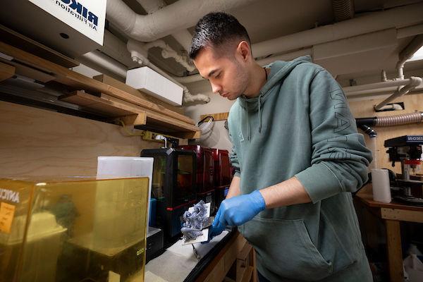 student holding molded object at MakerSpace 